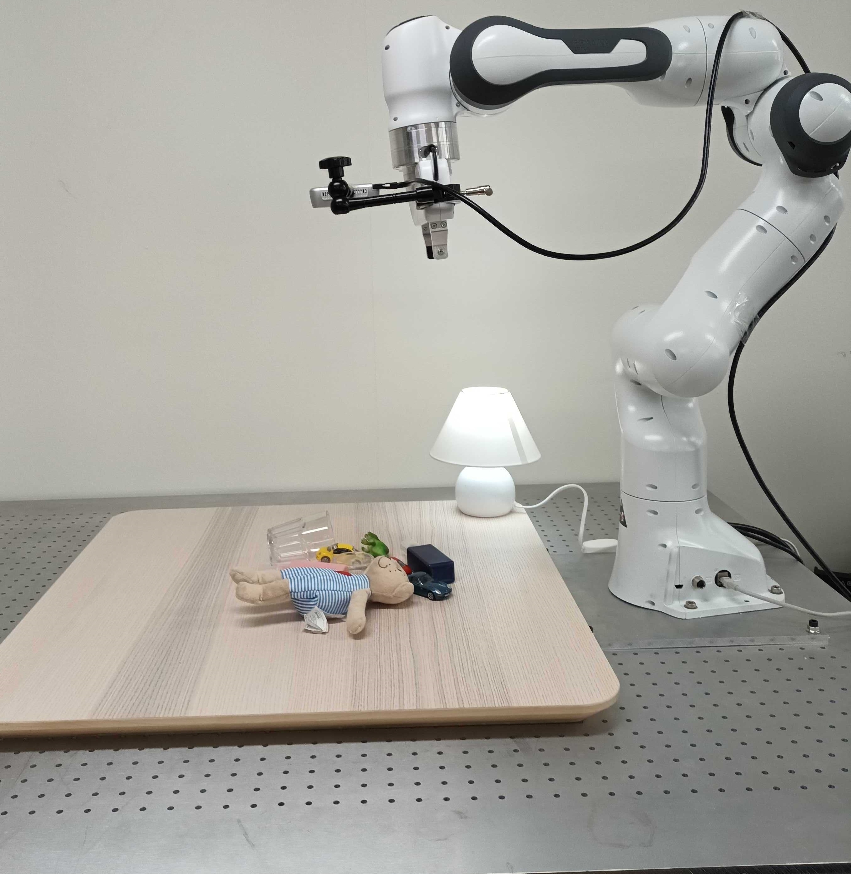 Robotic grasping environment with a Franka Panda arm above a set of transparent and opaque objects